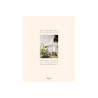 This image features the cover of a sophisticated coffee table book titled "Gathering" by Kristen Caissie, with additional photography by Simon & Mary. The cover design presents a minimalist yet elegant aesthetic, showcasing a subtle floral arrangement alongside a stylish handmade object, possibly a ceramic piece.