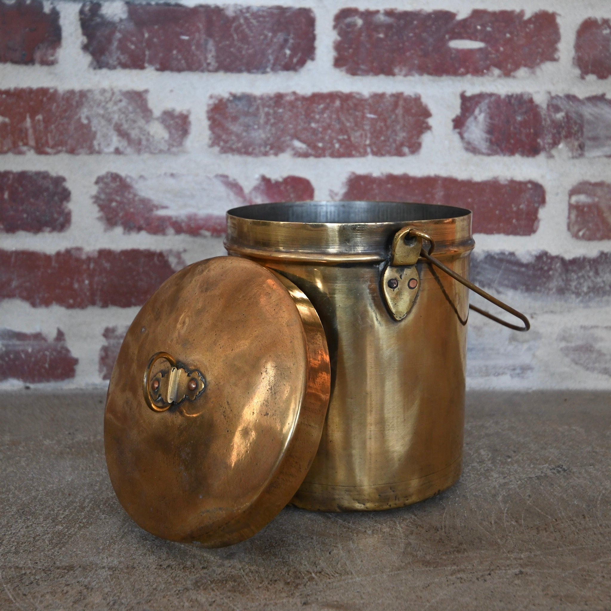 brass pot with lid and handle.