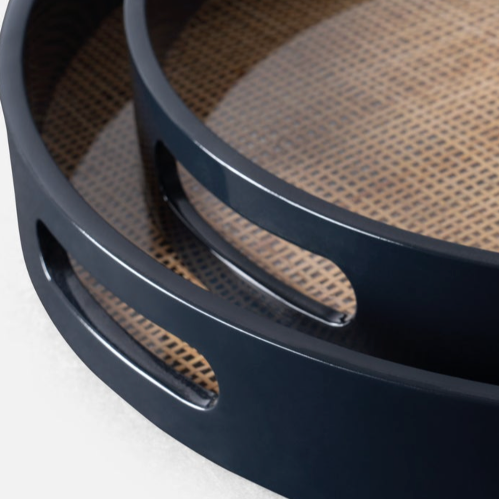 Elijah round tray set featuring two resin-encased cane rattan trays with glossy navy-varnished wood edges, elegant and sturdy for versatile use.
