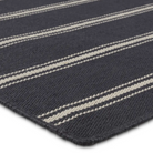 Navy stripe rug with handwoven flatwoven PET yarns, featuring thin and thick navy and ivory stripes, low 1/3" pile, durable polypropylene backing.