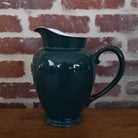 Antique teal green ceramic pitcher with graceful form and subtle patina, embodying elegance and refined craftsmanship.