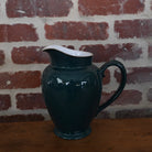 Antique teal green ceramic pitcher with graceful form and subtle patina, embodying elegance and refined craftsmanship.