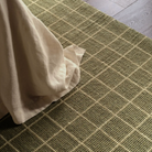 Windowpane Check Rug in olive green with handwoven 2/3-inch pile, durable wool and PET yarn blend, ideal for medium-traffic spaces.