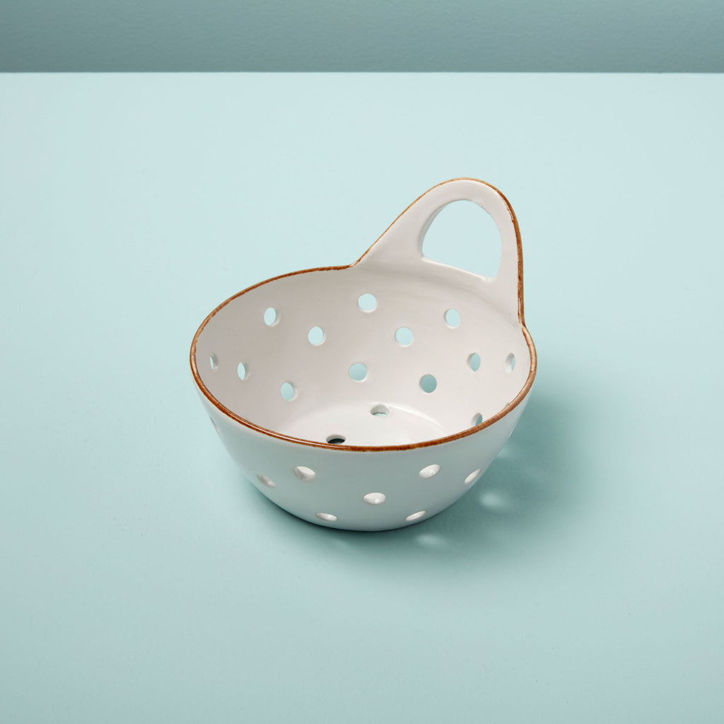 A white Stoneware Colander with Tan Rim: Versatile Elegance by BeHome, with polka dots on a light blue surface.