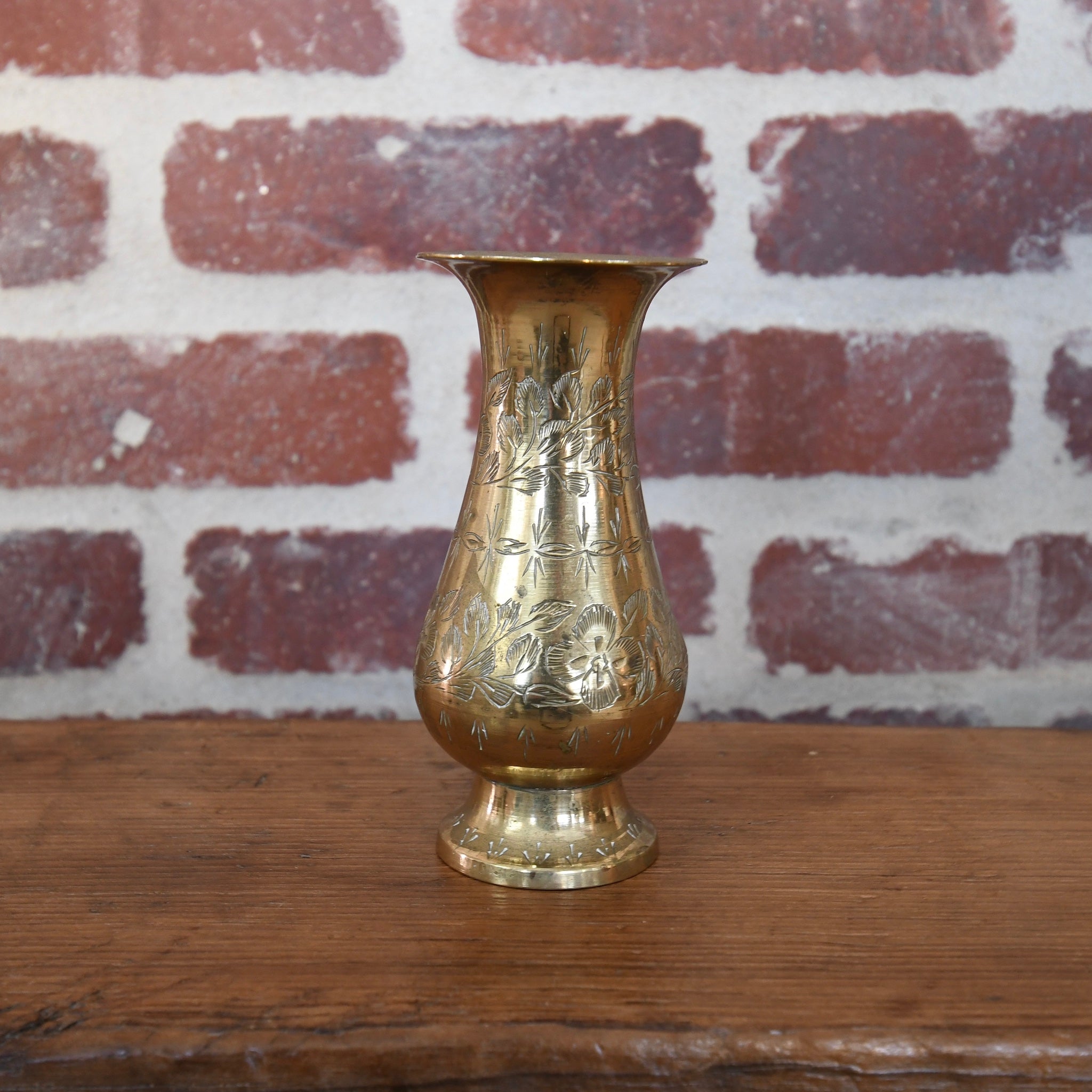 Antique brass bud vase featuring detailed floral engravings, vintage-inspired design ideal for displaying single flower stems or small bouquets in home décor.