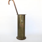 Sophisticated antique brass umbrella stand in mud room.