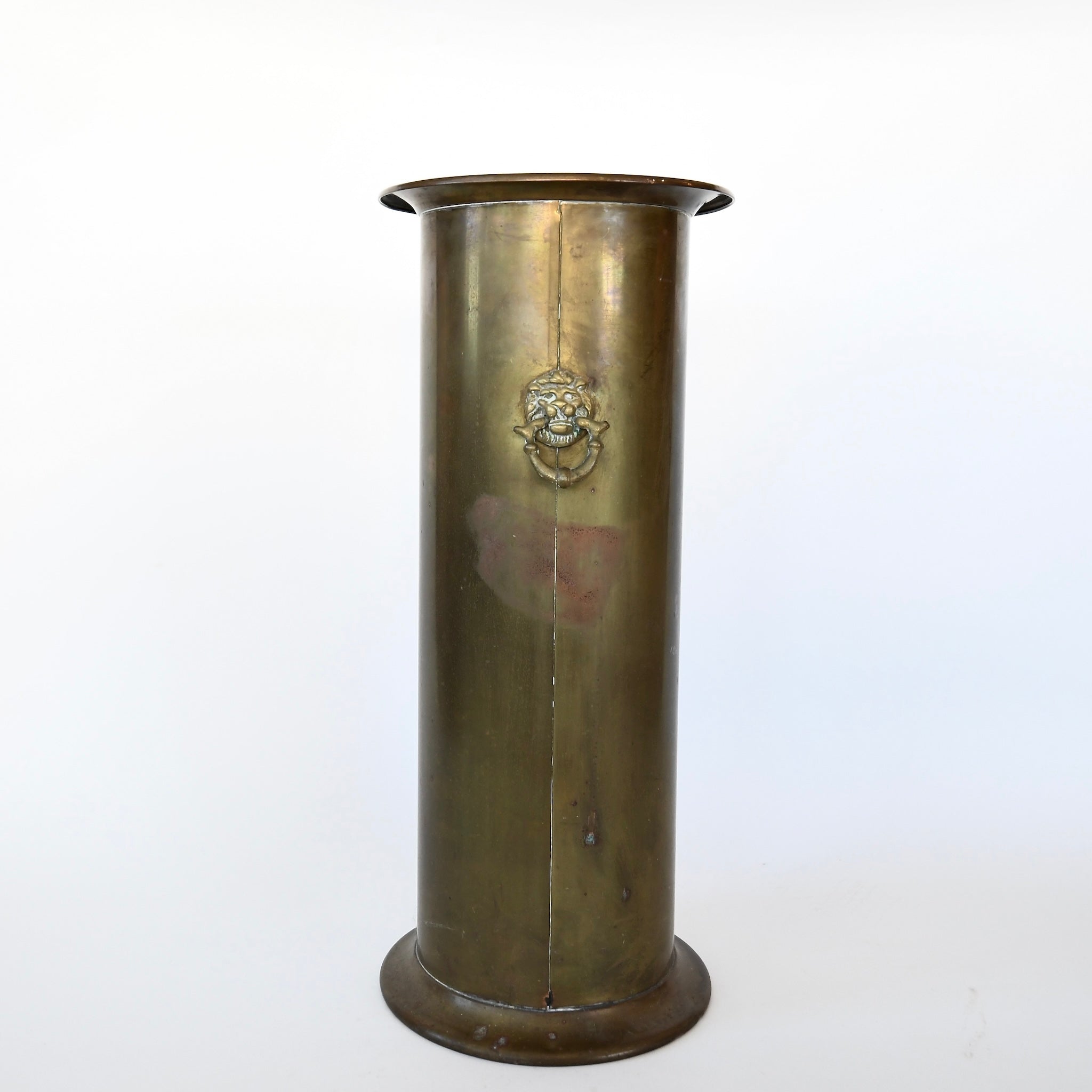 Antique brass umbrella stand with lion detail.