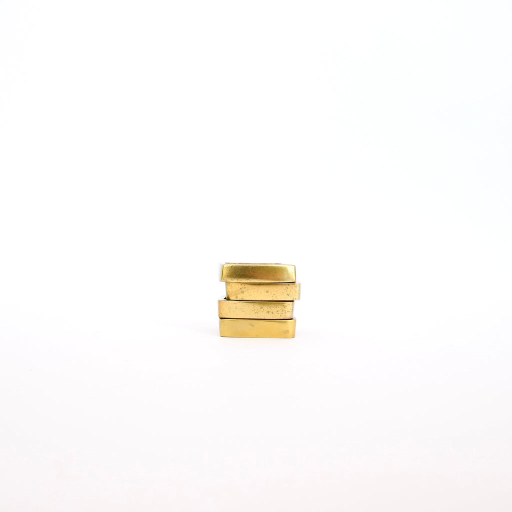 Three stacked Bloomingville Brass Tone Square Napkin Rings - Set of 4 with a brass tone finish against a white background.