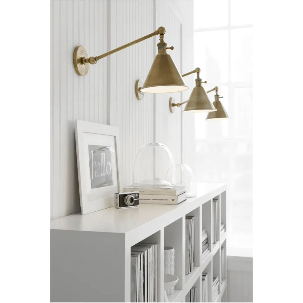 Stylish antique brass wall light for library and home office.