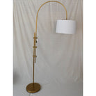 "Brass Arc Floor Lamp with Fabric Shade casting warm light in a modern living room"