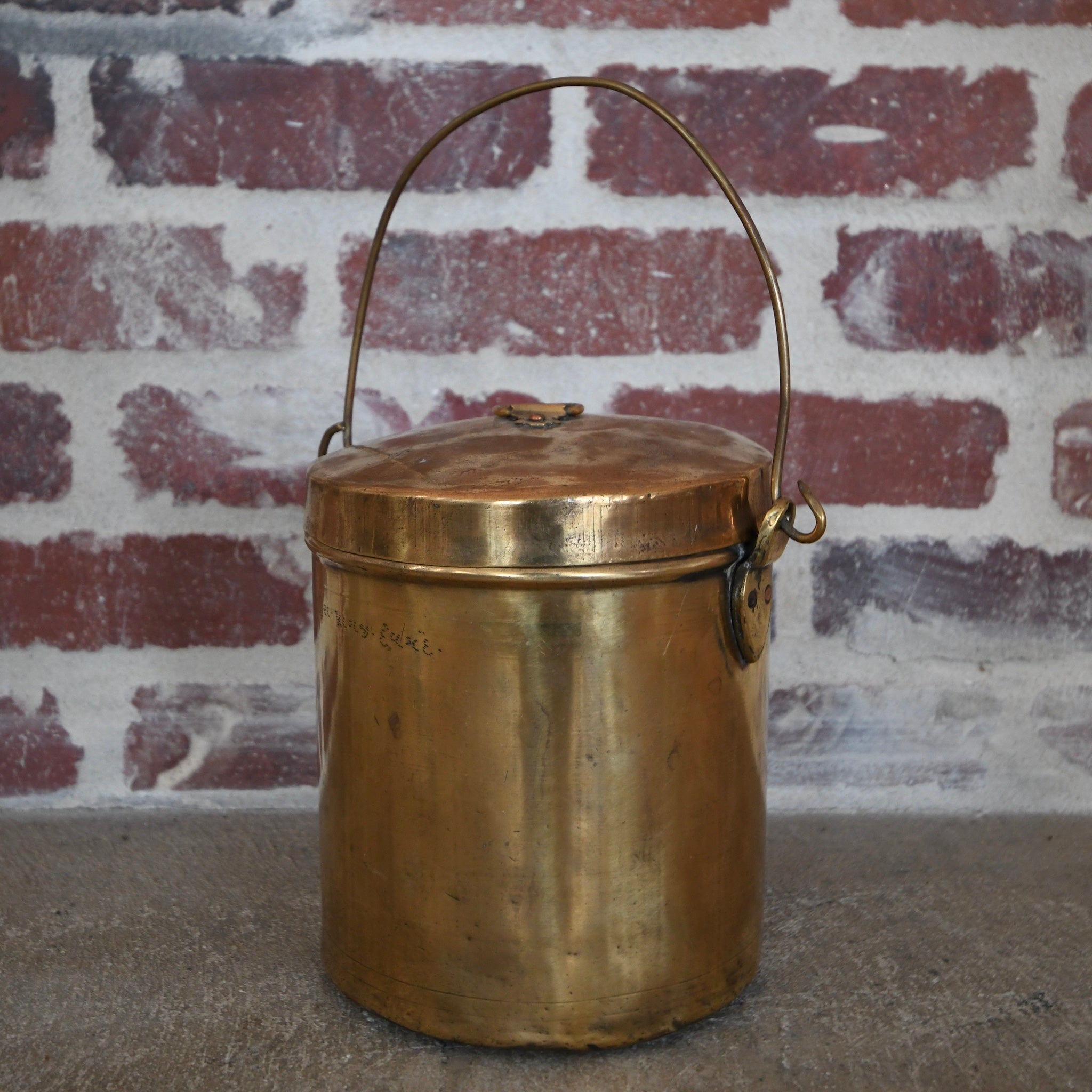 brass pot with lid and handle.