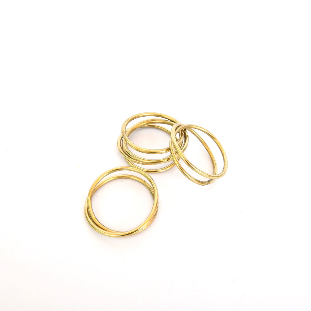 Four high-quality Bloomingville brass napkin rings on leather tie on a white background as table decor.