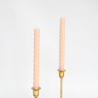 Set of two blush 10" twisted rope taper candles, hand-poured from pure beeswax in New York, burn clean and bright.