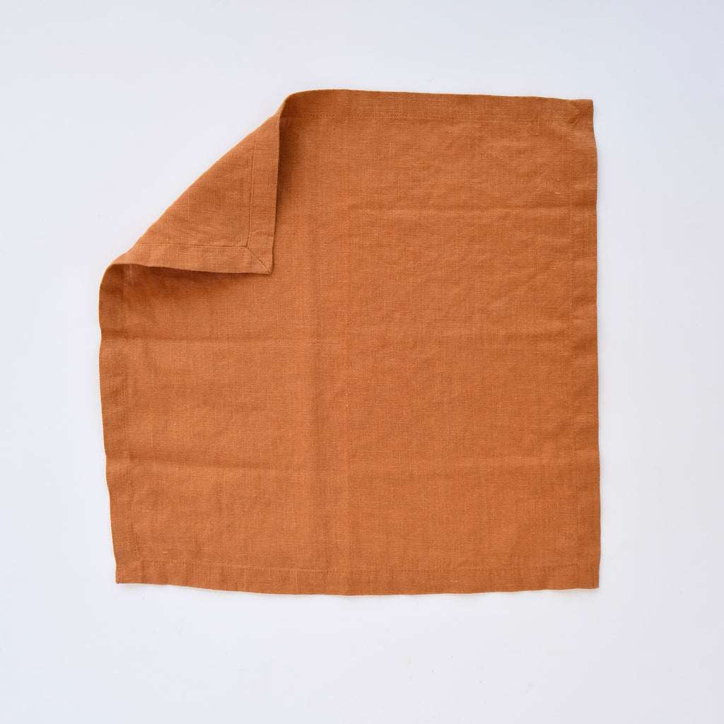 Folded Linen Tales Spiced Orange Linen Napkins (Set of 2) on a white background.
