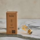 Tala Globe LED lightbulb, 6W clear round bulb with 600 lumens and warm 2500K color temperature, ideal for energy-efficient modern lighting.