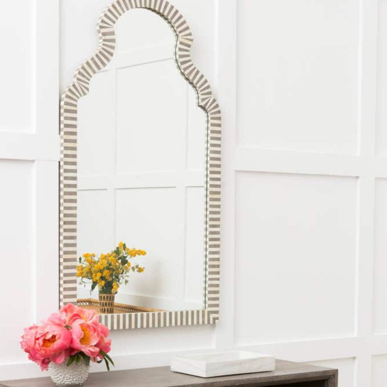 Sleek and stylish Jonah Mirror with white bone and gray resin frame.